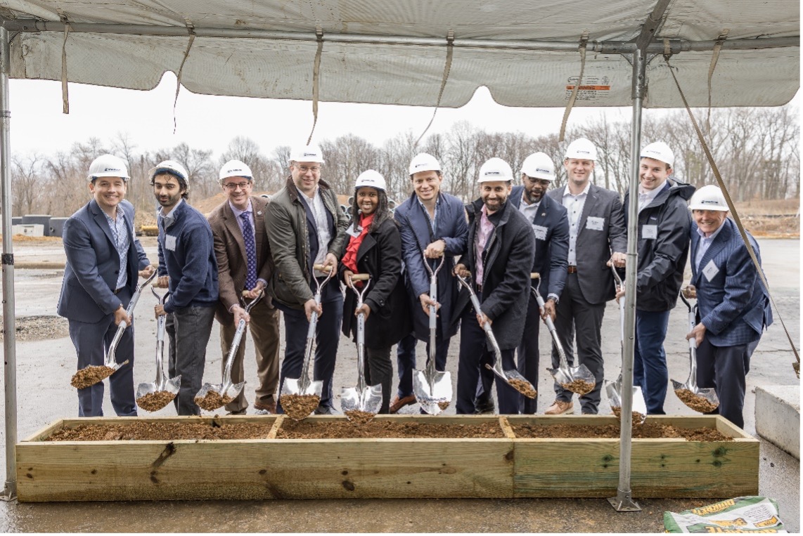 a group of people in suits break ground at Jefferson Plaza