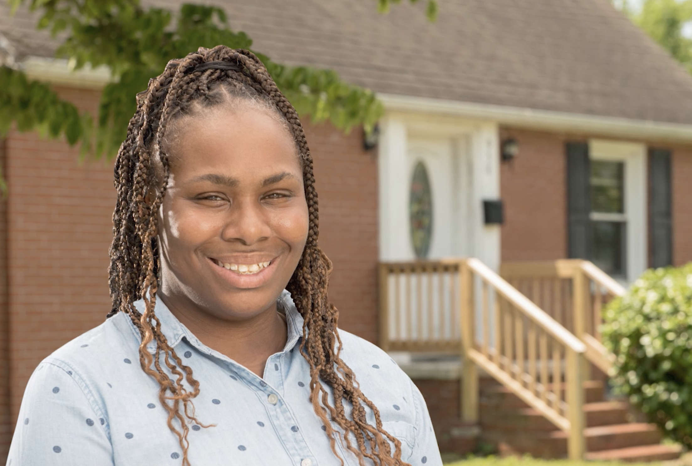 Rhonda Barrett, Homeowner, smiles in front of her home